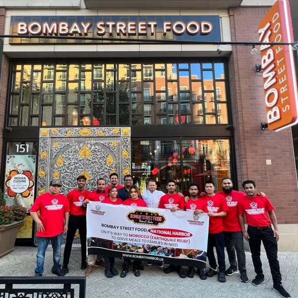Bombay Street Food staff holding a banner for Morocco earthquake relief in front of the restaurant.