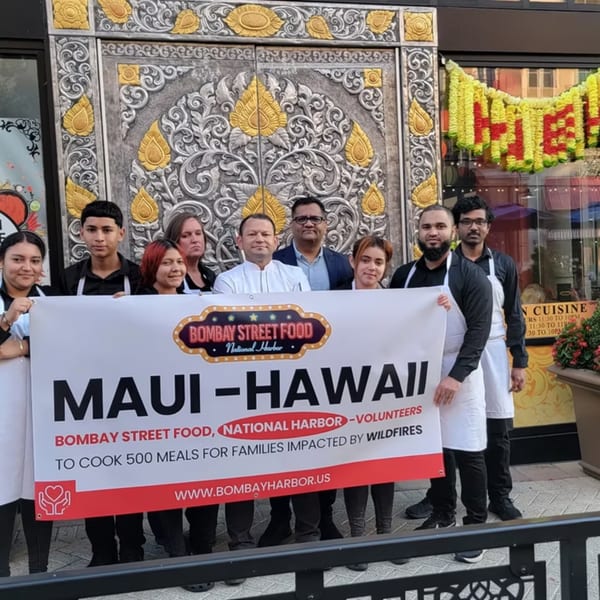 Bombay Street Food National Harbor staff holding a banner for Maui-Hawaii wildfire relief efforts.